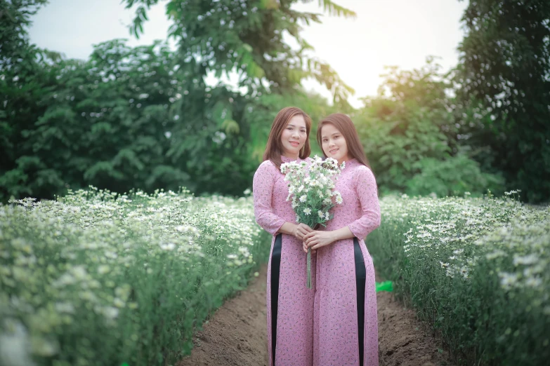 two women are holding a bouquet of white flowers