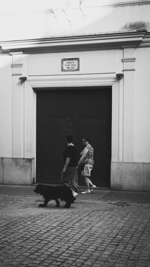 people walking down the street with their dog