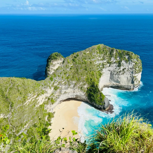 the blue ocean is in front of a rocky island