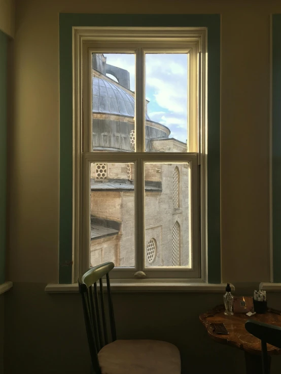 view of city outside of a window with a chair sitting near it