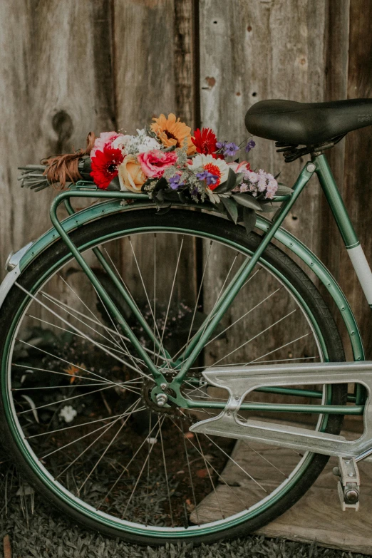 a bicycle is parked near a wooden fence with flowers in the basket