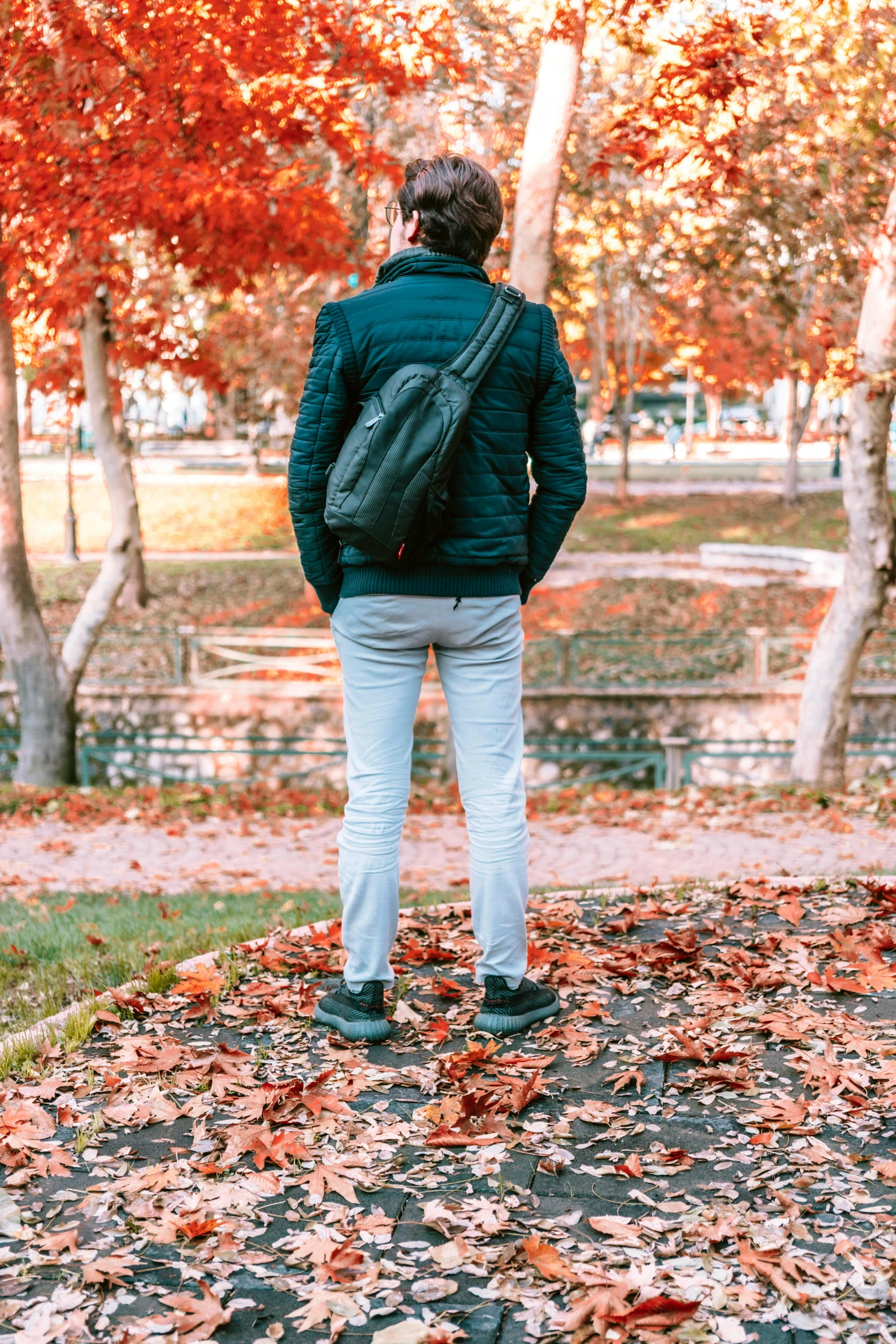 a person with a backpack is standing near some trees