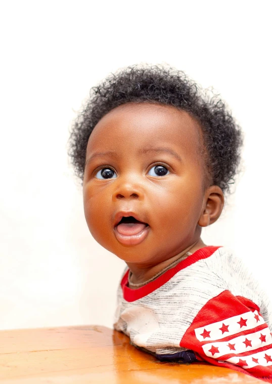 a close up of a baby sitting at a table