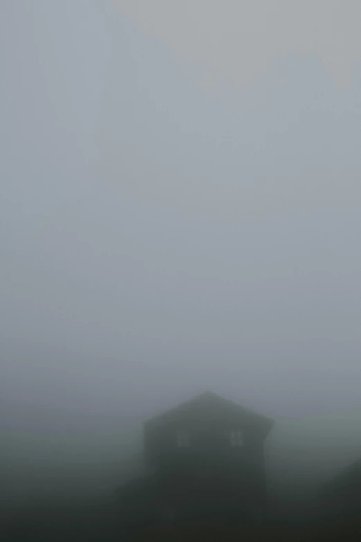 a car traveling down a foggy road on top of a hill