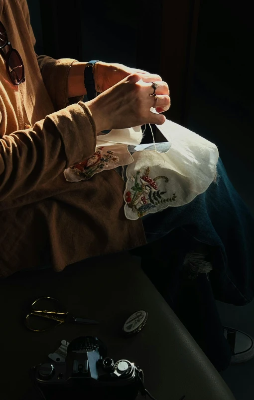 person sitting at a desk holding several items in their hands