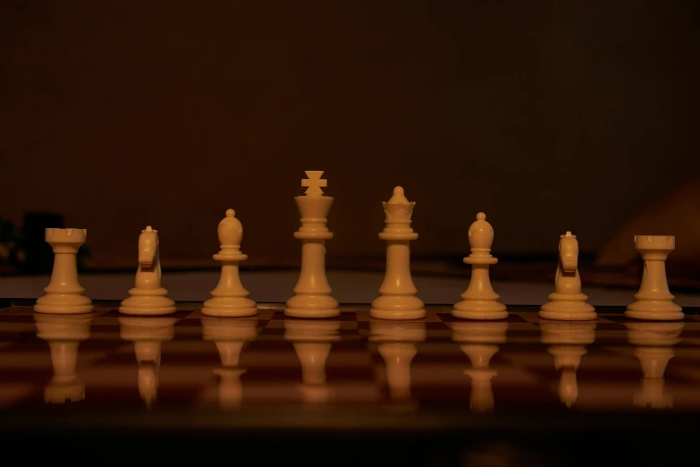 chess figures are on a table next to a brick wall