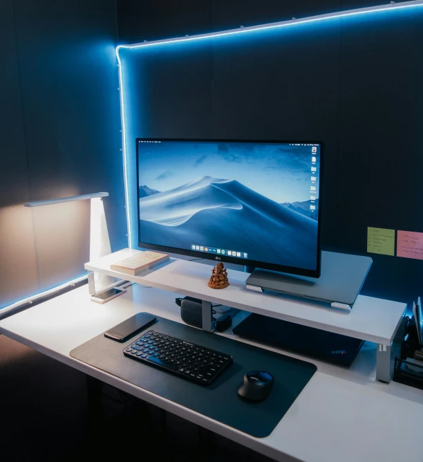 the desk has a computer on it and a clock