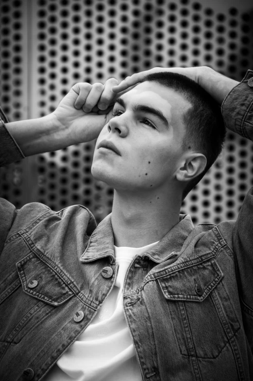 a young man standing in front of a metal screen