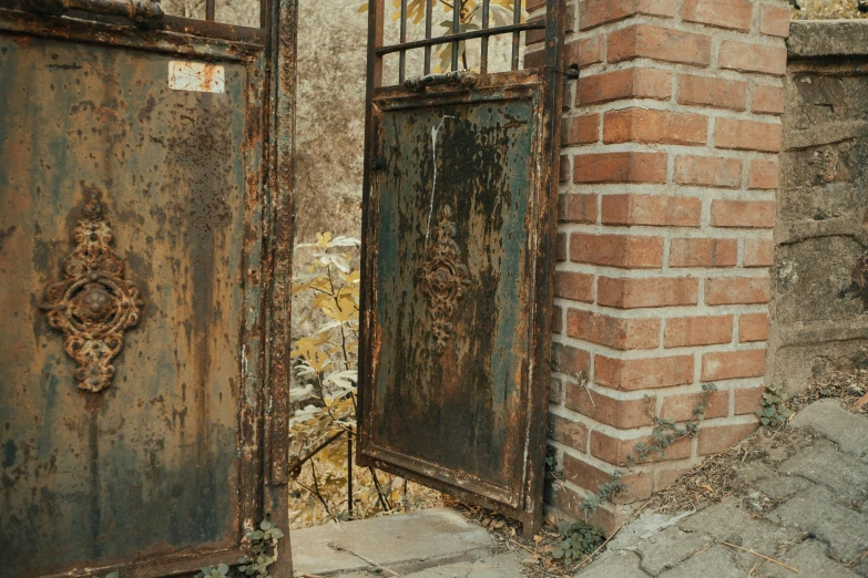 two rusty doors that are in front of a building