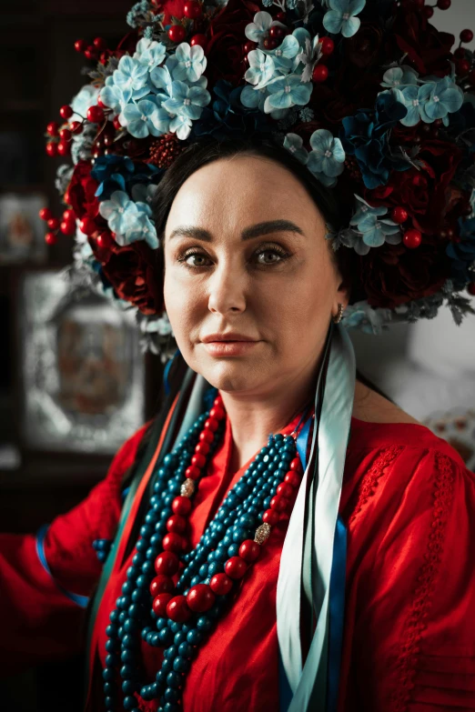 a woman with flowers is dressed up in beaded headdress