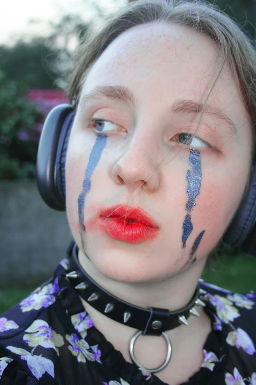 the girl has her face painted in blue and purple