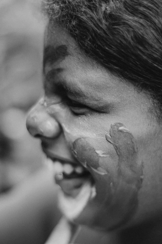 a boy smiling and getting his face cream poured on his nose