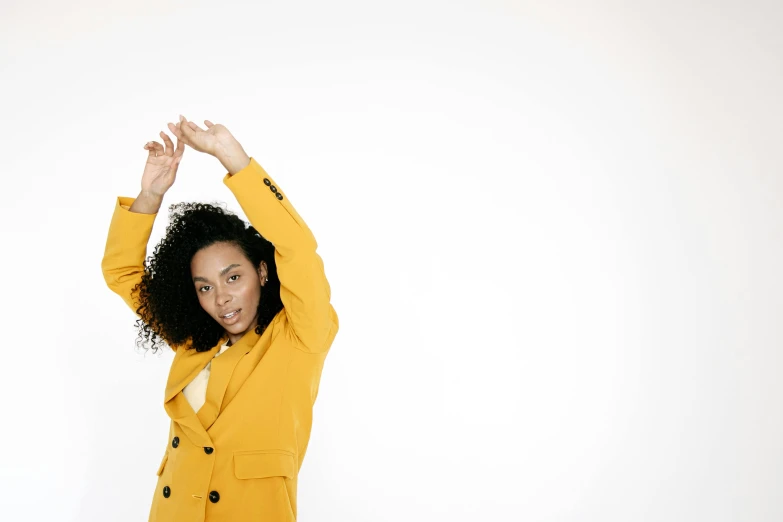 a woman in yellow is raising her hands