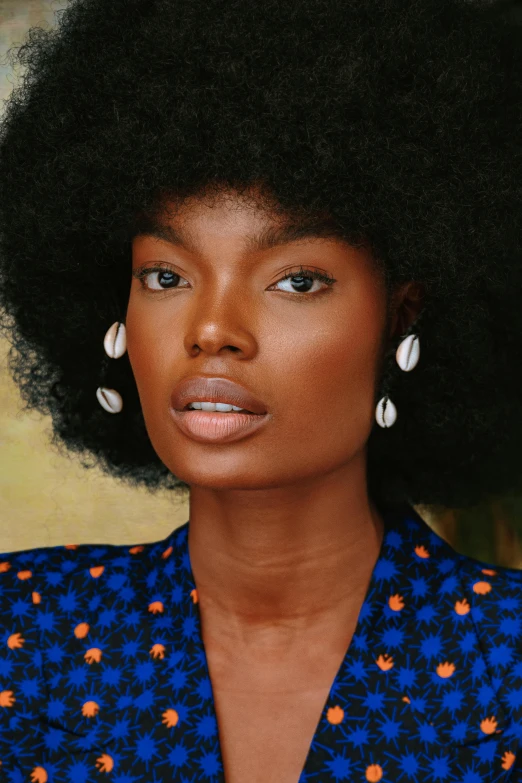 a woman with large black afro wearing earrings