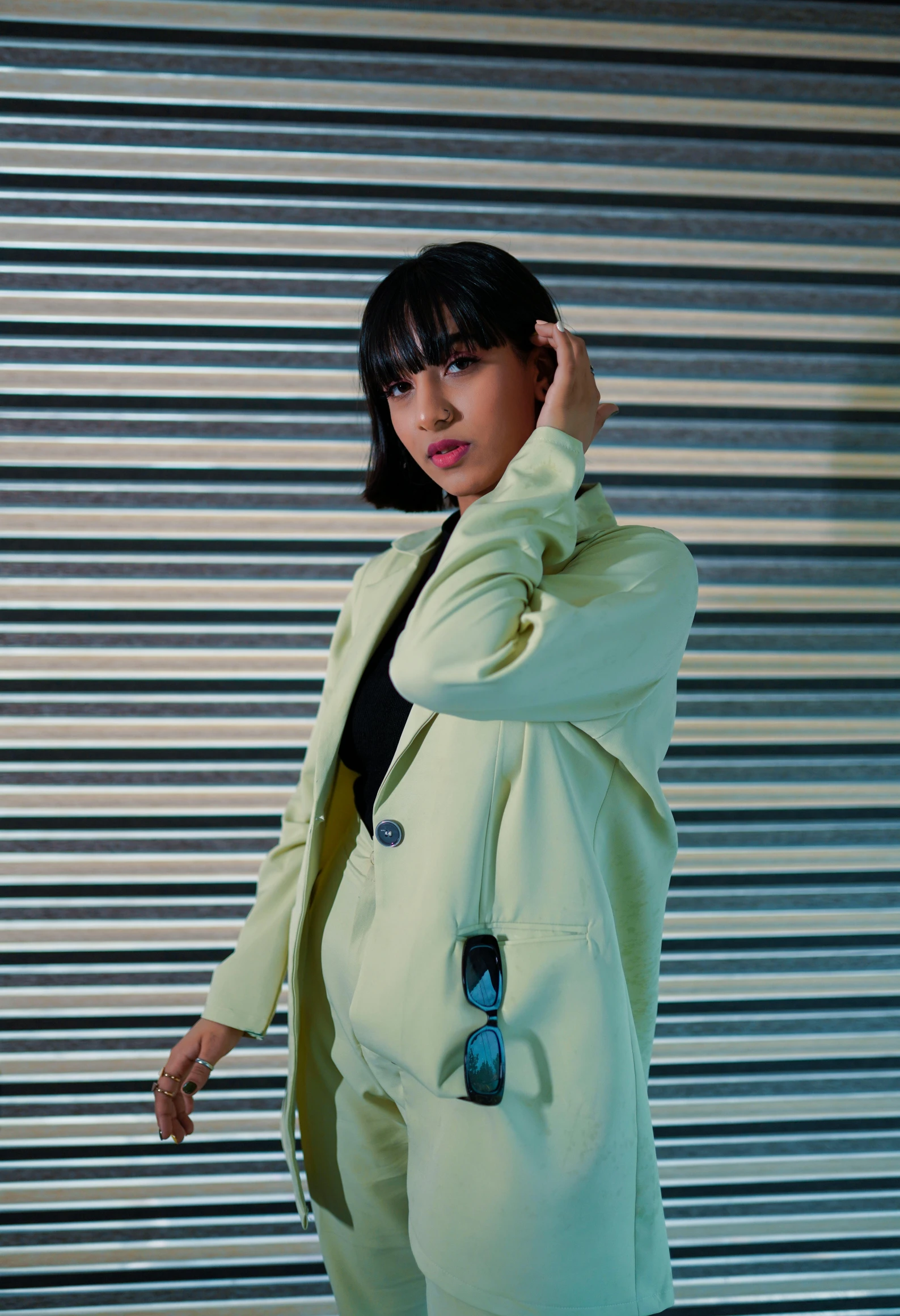 a person wearing all white clothing standing in front of a metal wall