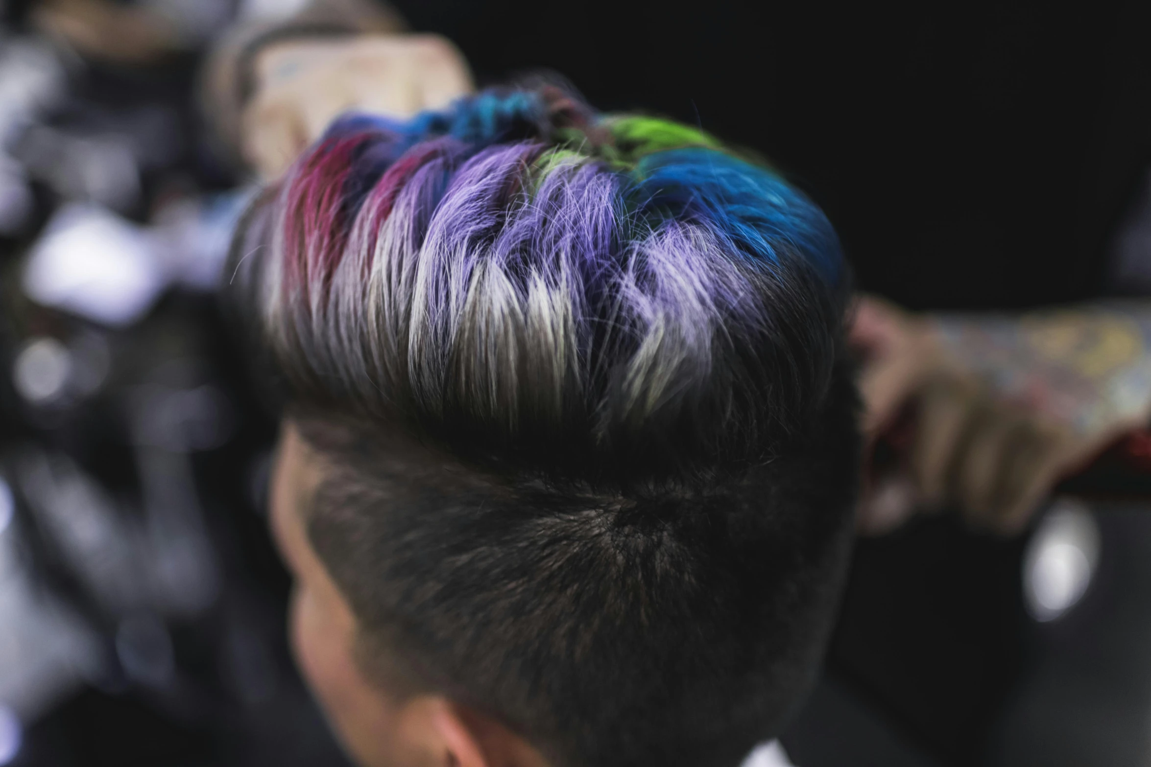 the hairdresser is displaying his multicolored mohawk