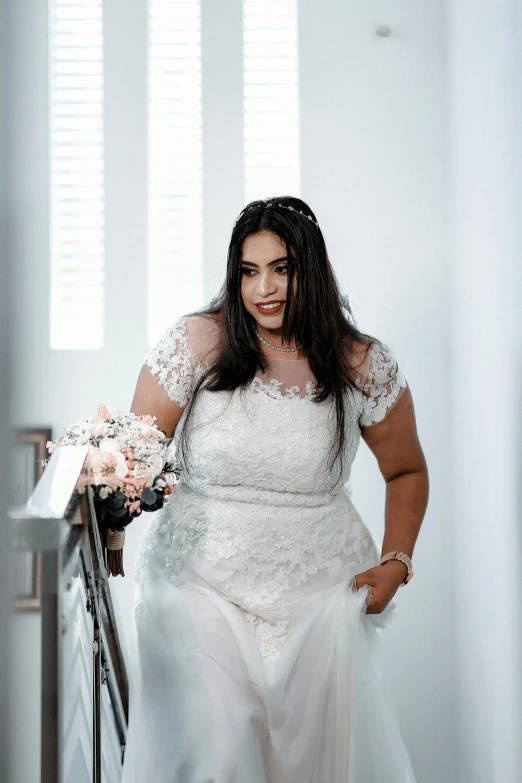 a woman in a white wedding dress leans on a railing