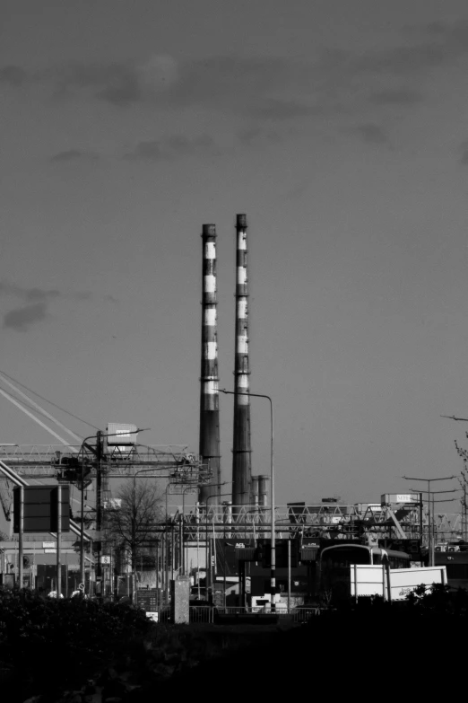 a black and white image of factory chimneys