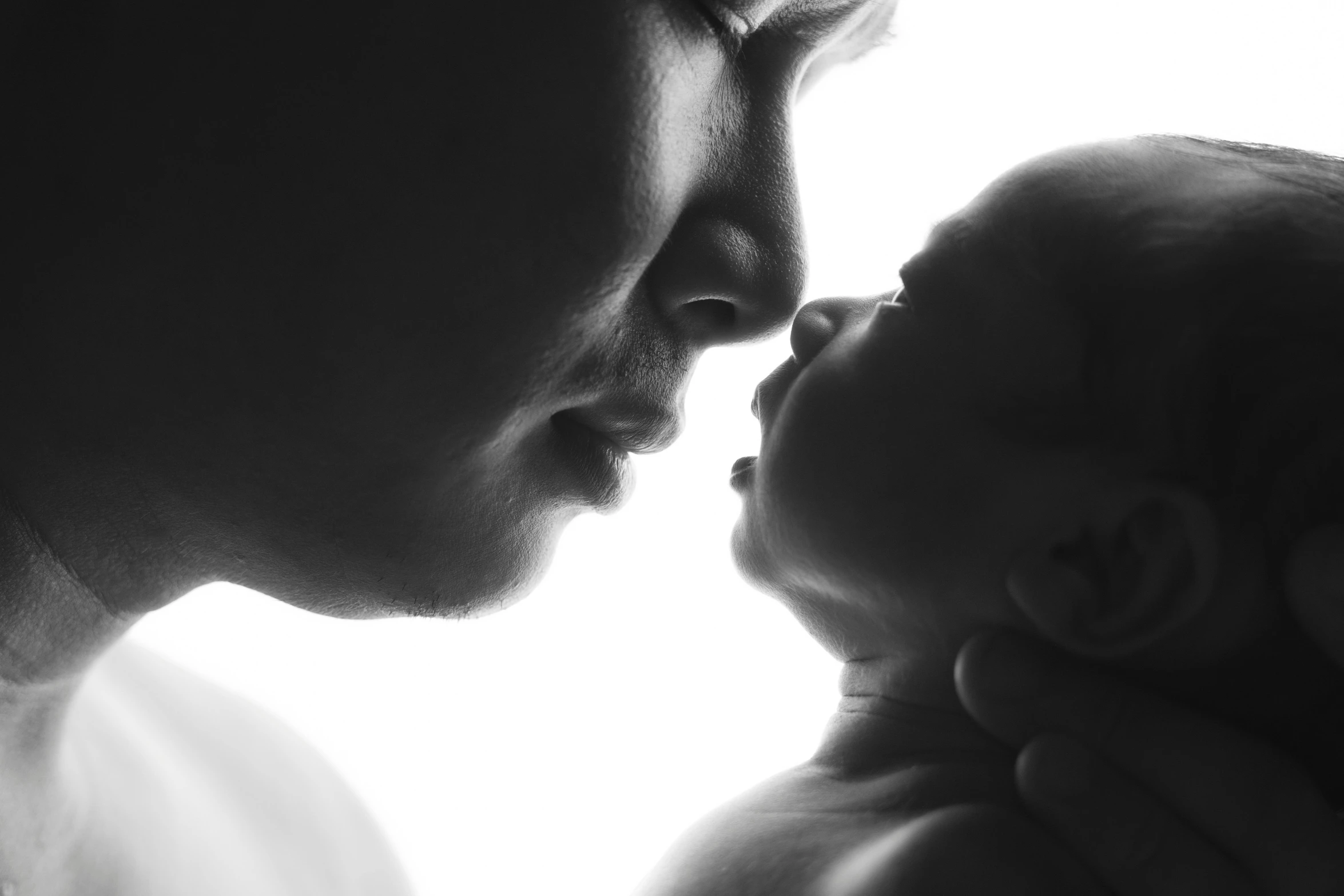 a man holding his baby and kissing it