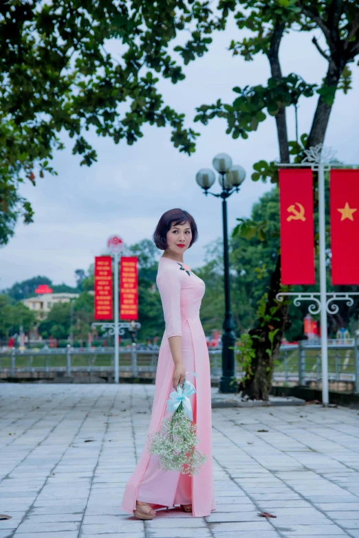 an asian lady with a bouquet in hand poses for a picture