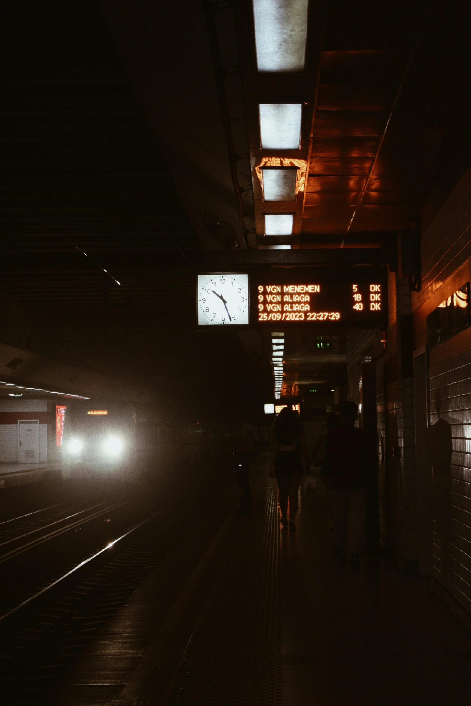 a group of people walking towards a train platform