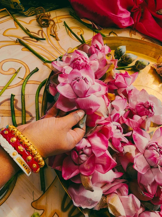 a person is preparing pink flowers for crafts