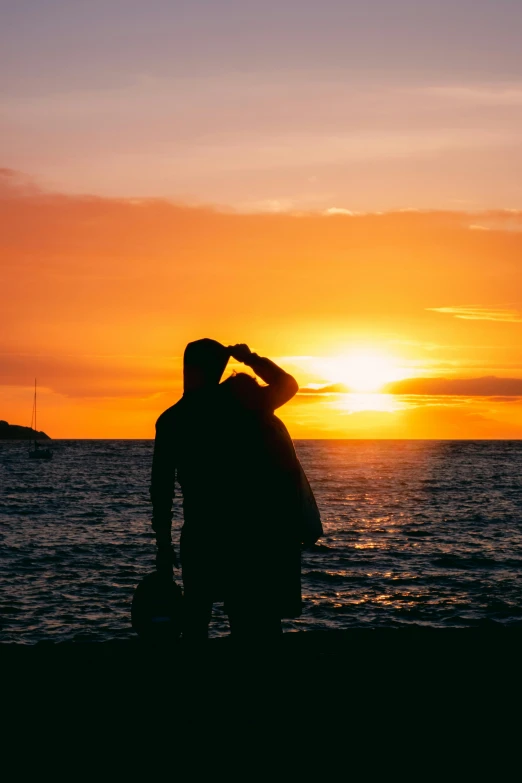 a man is looking at the sun over the ocean