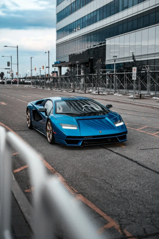 a blue sports car parked on a city street