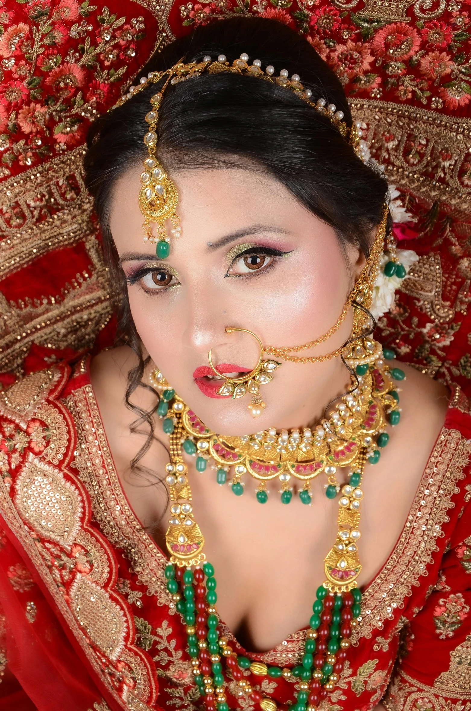 a woman wearing necklaces and jewelry in a red outfit