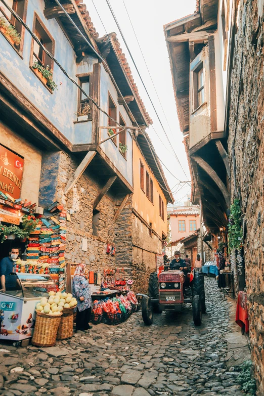 the narrow street is full of people and vegetables