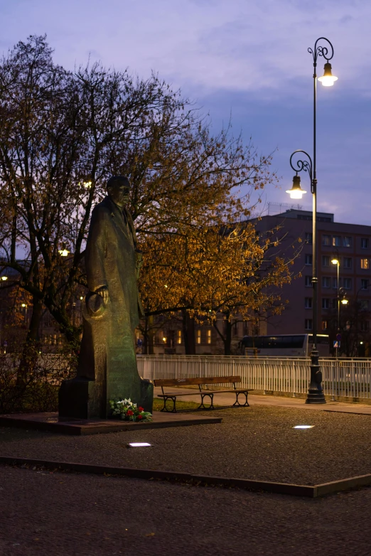 a couple of street lamps on poles near a statue