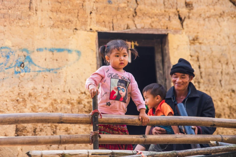 a woman and child standing on top of a wooden fence