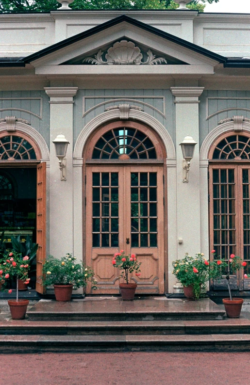 the potted flowers are on the step outside the house