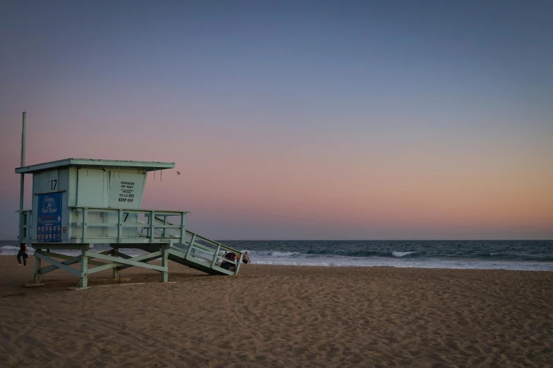 a lifeguard tower on a sandy beach near the water