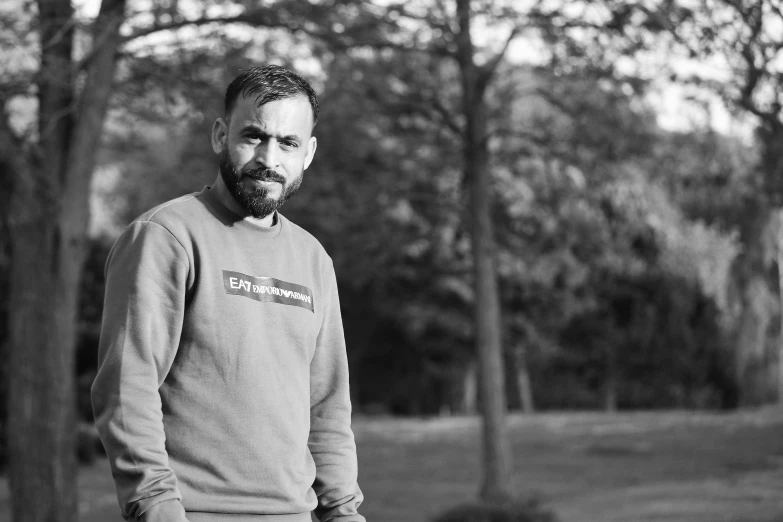 a man in black and white is standing in a park