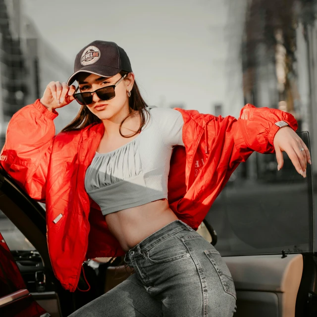 a woman wearing sunglasses and a red jacket in a car