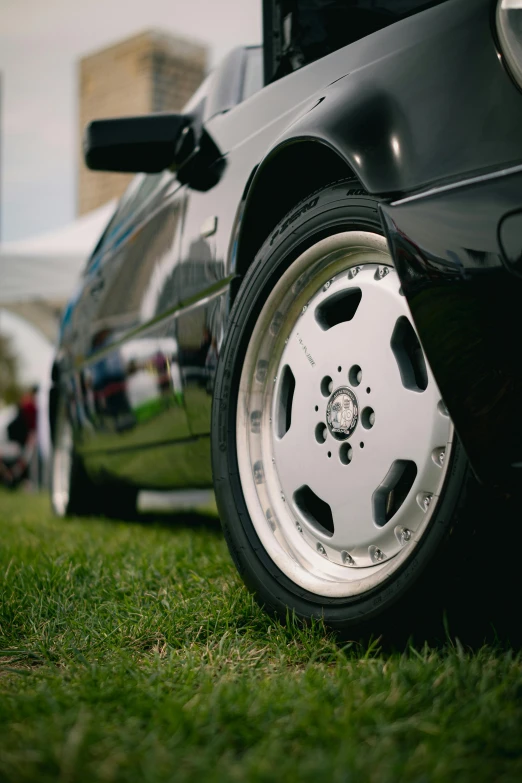 a black car parked in the grass in the evening