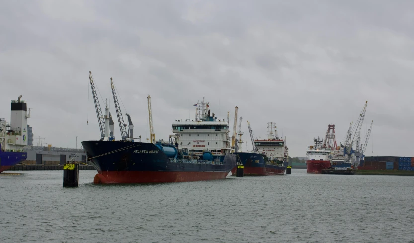 two huge ships docked at the dock with other ships in the background