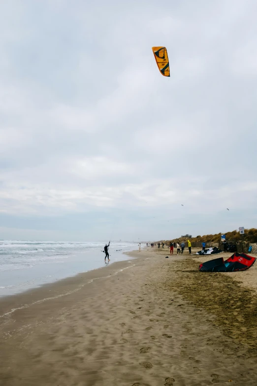 a couple people walking on the beach next to surf boards