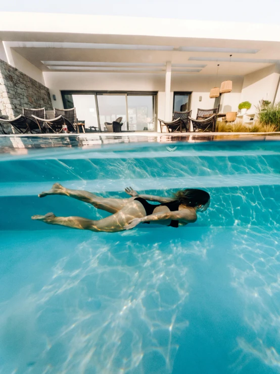 a woman is floating in the pool and she is in very clean water