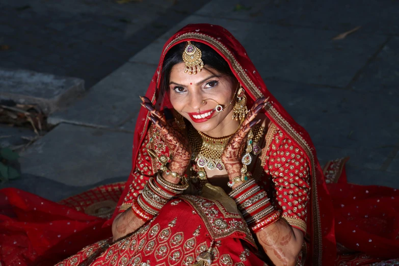 a woman in a red and gold traditional indian outfit
