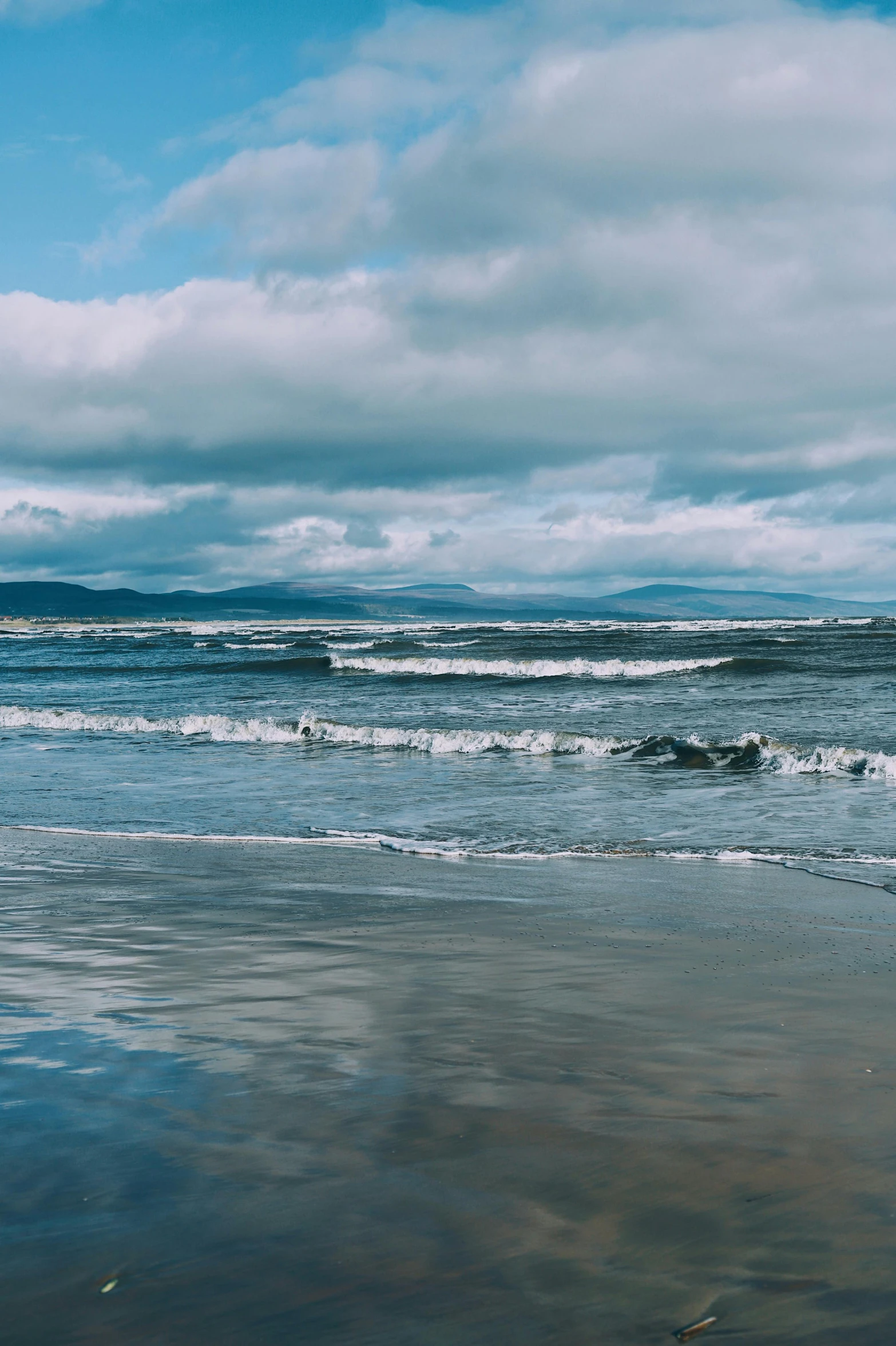 a small wave breaking on the beach by itself