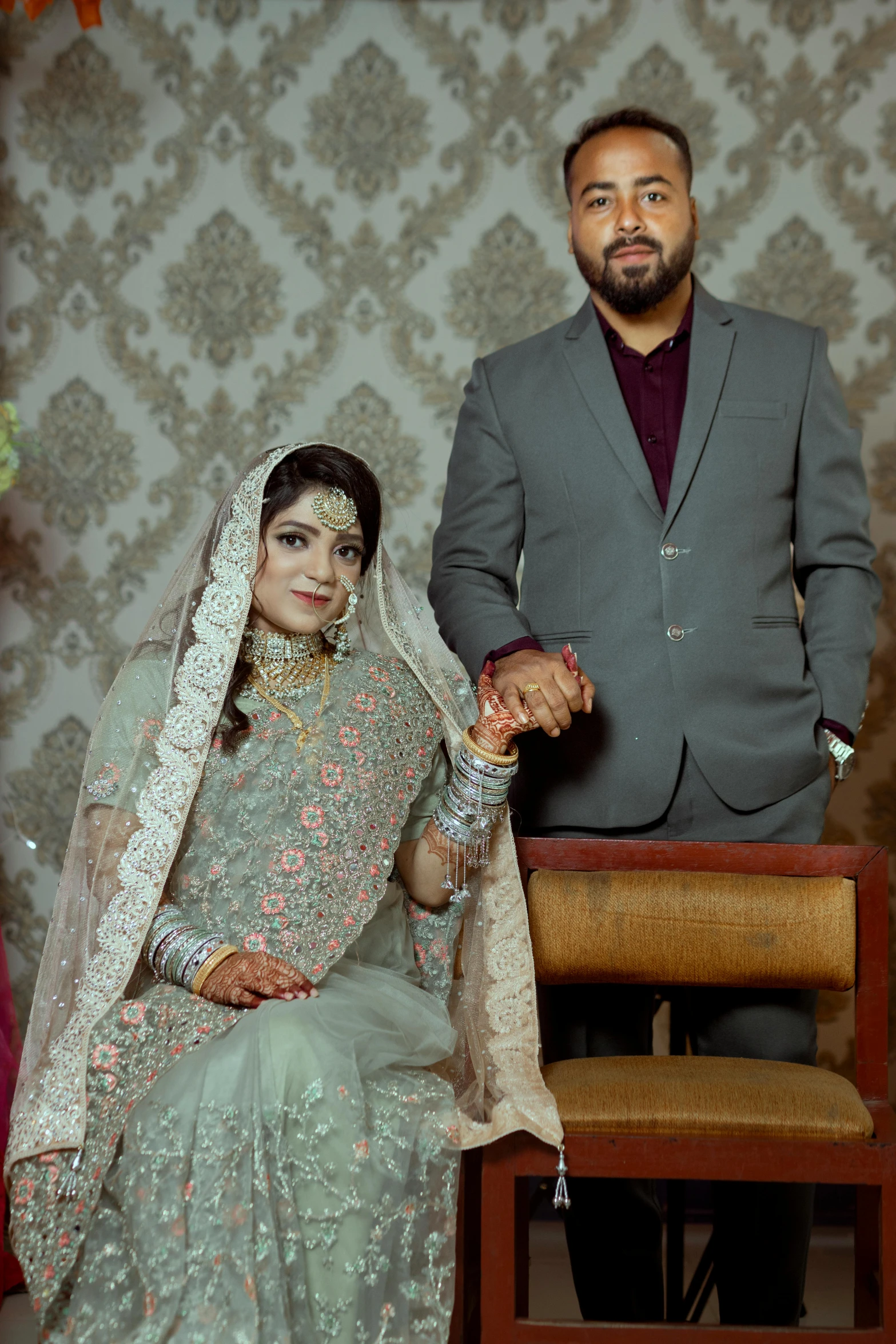 an indian man and woman holding hands and posing for the camera