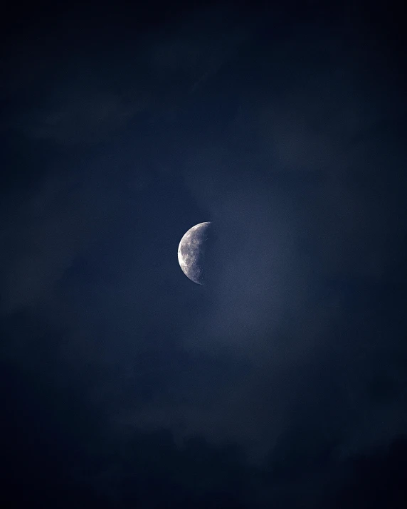 a moon shines over the horizon at night