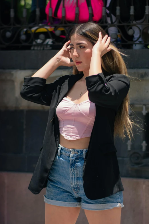 a girl in shorts poses on the sidewalk