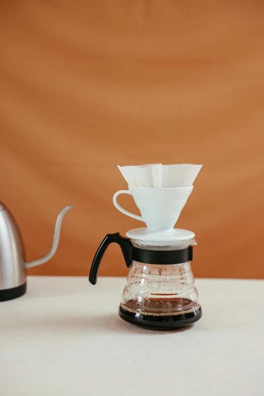 three cups are on top of the coffee maker