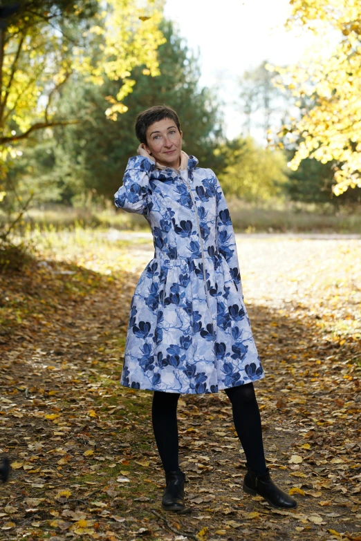 woman in an artistic dress standing outside, talking on the phone