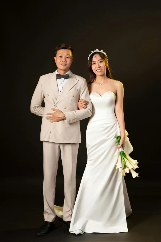 an asian bride and groom are posing for a portrait