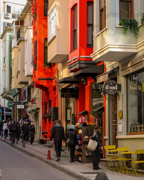 a street that has a bunch of people walking on the sidewalk