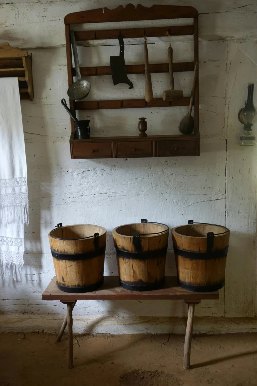 a wood counter with three buckets on top